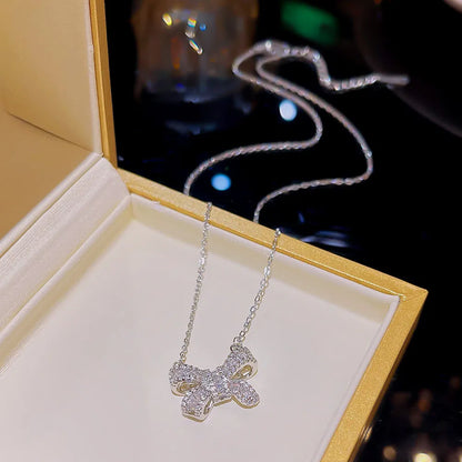 The Bow Necklace in its box