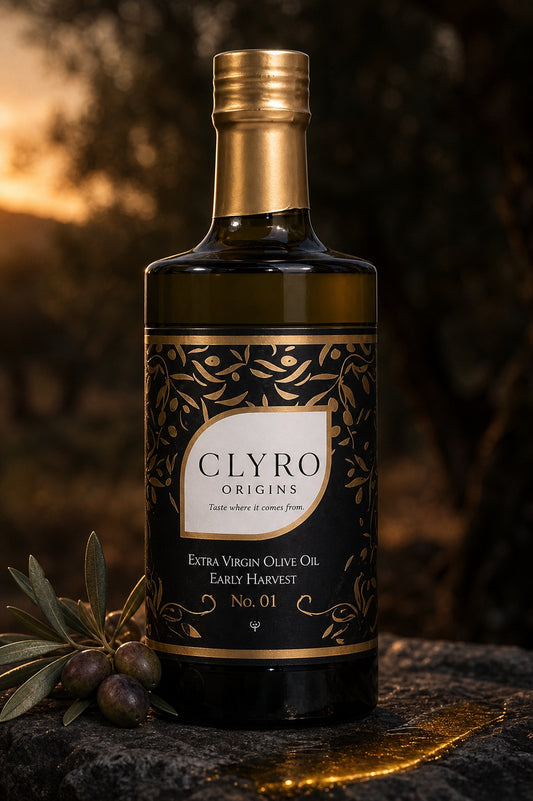 Clyro Origins early harvest extra virgin olive oil, 500 ml dark glass bottle with gold capsule, on stone at dusk in an olive grove