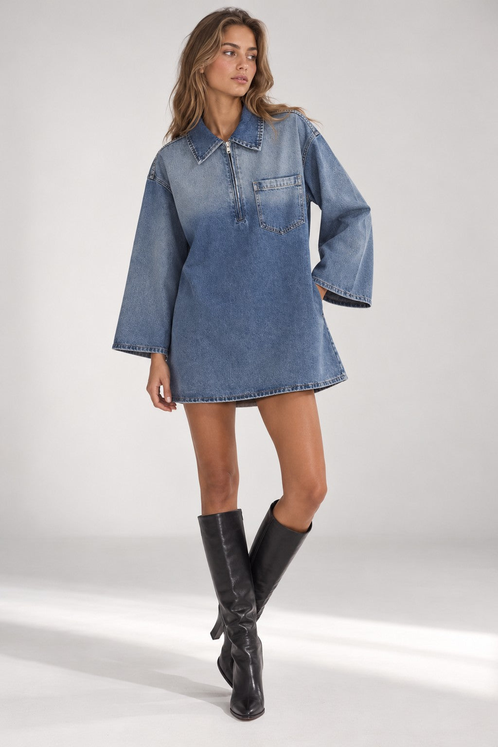 The Half-Zip Denim Dress in Washed Blue, worn with knee boots