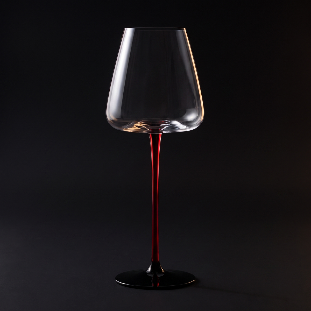 White wine glass on the scarlet stem, black ground