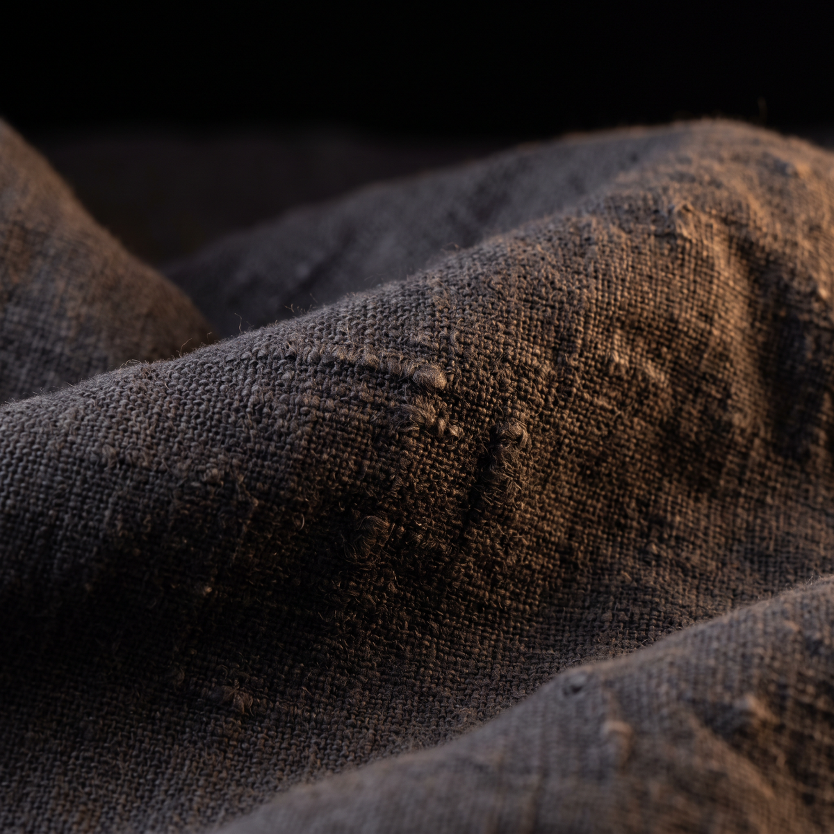 The weave, close — stone-washed charcoal flax linen