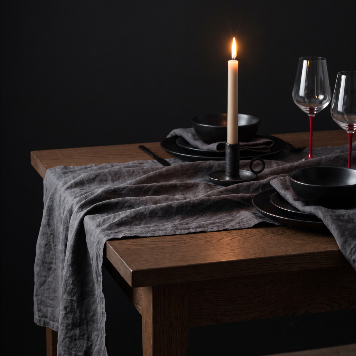 The cloth dressed for dinner — black porcelain and a single taper