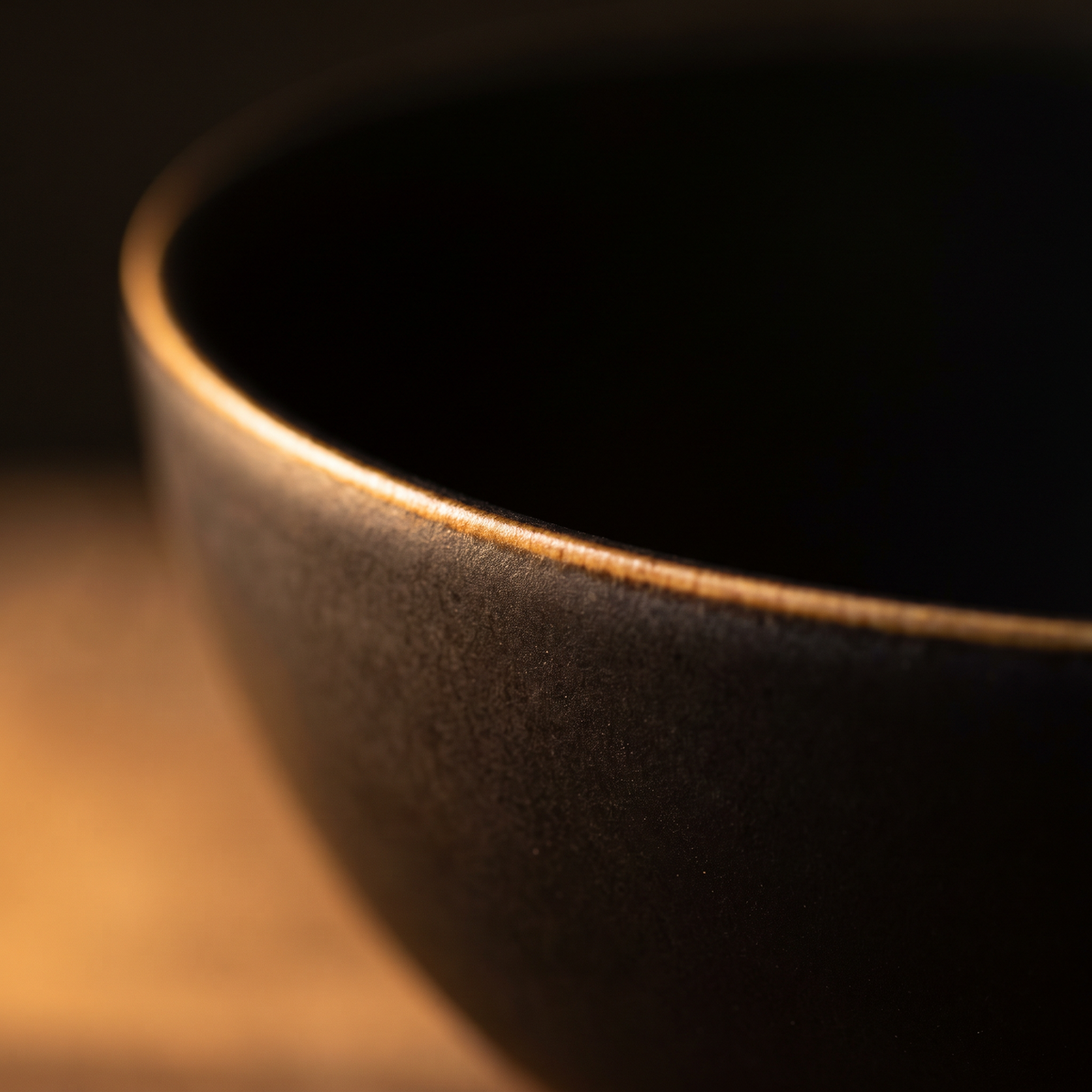 The rim — satin glaze breaking to raw porcelain