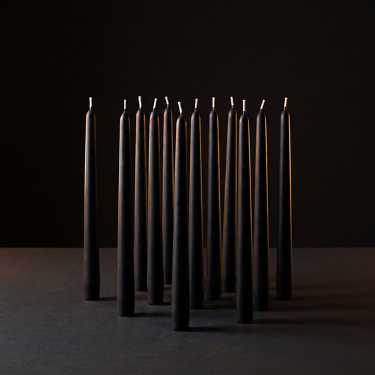 Twelve matte black tapers, unlit
